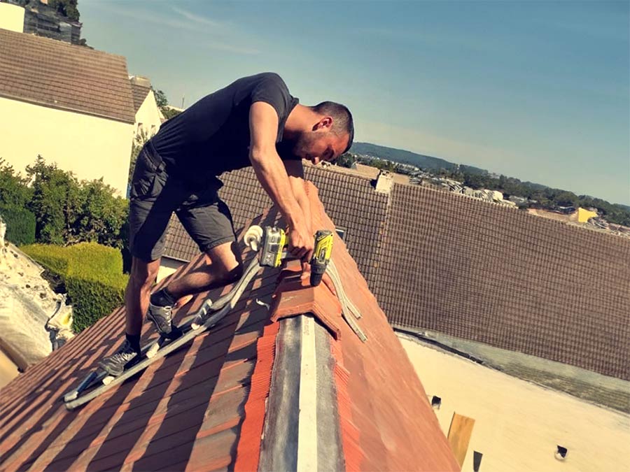 Artisan en train de refaire un toit à Méru