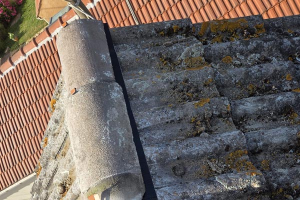 Toit d'une maison à Mouy qui a du lichen sur les tuiles.